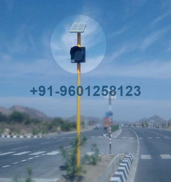 Pole-mounted solar traffic signal blinker light with integrated solar panel on a roadside